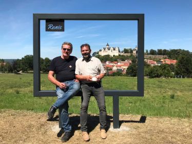 Zwei Personen sitzen am Fotorahmen in Ranis